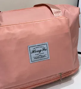 Detailed close-up of pink waterproof nylon travel bag with brand patch and stitching