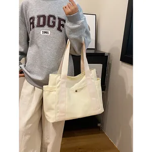 Bolso tote de lona color crema grande con bolsillos laterales para el uso diario