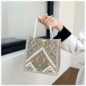 Detailed macro view of ethnic canvas tote featuring vibrant woven texture and embroidery