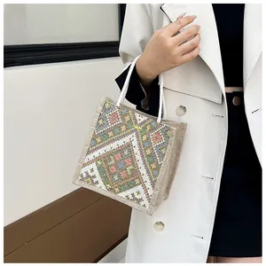 Detail of ethnic geometric embroidery and woven texture on this stylish canvas tote bag