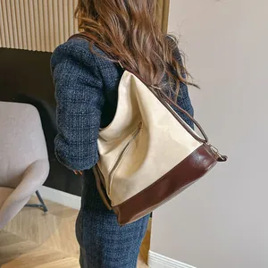 Bolso tote retro de gran capacidad en cuero crema y marrón mostrado en modelo