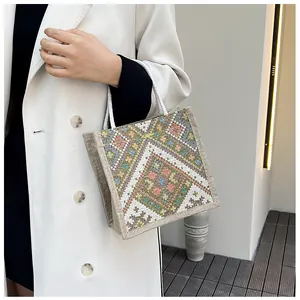 Close-up of ethnic style canvas bag with colorful geometric woven patterns and rope handles