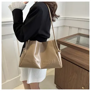 Detail of khakhi tote bag with embossed letters and stylish knot strap detail