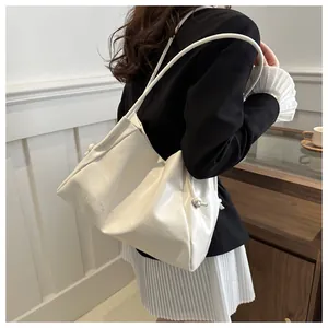 Detailed side view of white pleated tote bag with WIGUA embossed logo and knotted strap