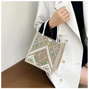 Detailed view of canvas tote bag featuring colorful ethnic geometric woven patterns