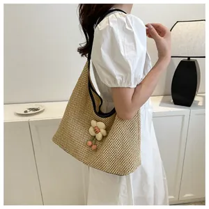 Detalle del bolso tote de paja hecho a mano con flores 3D y colgantes de cerezas rojas