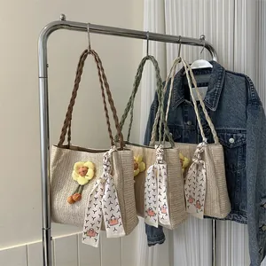 Women's woven straw tote bag with flower charm and scarf handle for summer beach