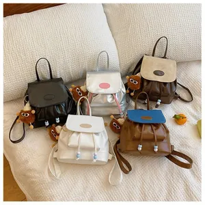 Mini PU leather backpacks in five colors with drawstring closure and plush monster charm