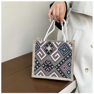 Ethnic style linen handbag featuring colorful geometric patterns and white rope handles