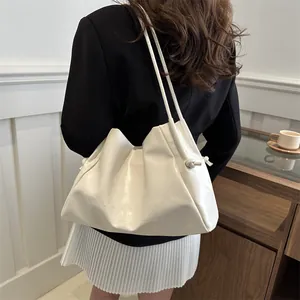 White leather tote bag with embossed letters and shoulder straps for daily commute