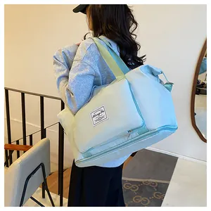 Macro view of light blue travel bag with separate bottom compartment and green handles