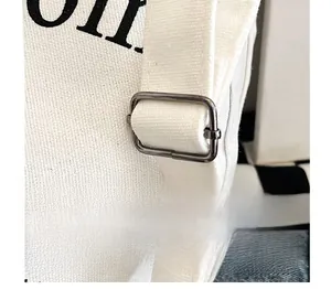 Détail macro de la boucle réglable en métal de la bandoulière sur sac en toile blanche