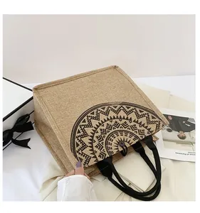 Detalle del bolso de lino con diseño de mandala negro y cierre de botón seguro