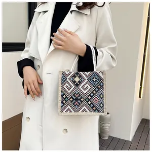 Detailed close-up of ethnic woven canvas bag with geometric patterns and rope handle