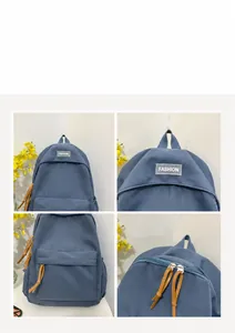 Detail of dark blue canvas backpack with double zippers and brown leather pulls