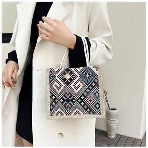 Close-up of ethnic style linen tote with geometric embroidery and rope handles