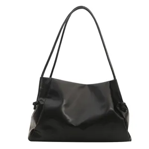 Minimalist black PU leather tote bag with drawstring detail and glossy finish for women