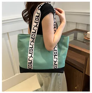 Sac fourre-tout en toile vert menthe avec bandoulières à motifs noirs sur mannequin