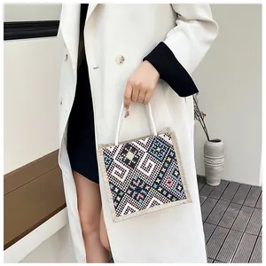 Detail of ethnic canvas tote featuring colorful geometric patterns and white woven handles