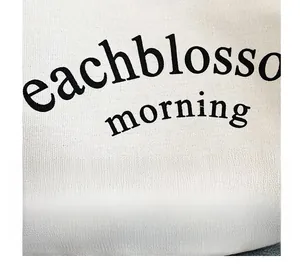 Gros plan détaillé montrant la texture de la toile et les lettres artistiques sur le sac