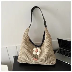 Detalle del bolso tote de paja tejido a mano con flor 3D blanca y correa de cuero