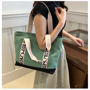 Détail du sac cabas en toile verte avec bretelles imprimées et fond noir durable