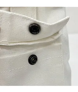 Gros plan sur le fermoir magnétique noir robuste sur un sac fourre-tout en toile blanc