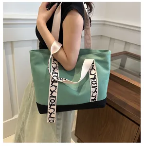 Détail du sac fourre-tout en toile bicolore vert et noir avec bandoulière à lettres