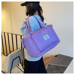 Detail shot of a purple waterproof travel bag with reinforced straps and expander base