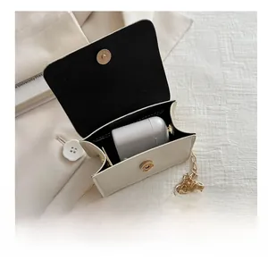 Detailed interior view of a beige mini flap bag showing capacity for wireless earbuds