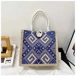Detail of blue ethnic geometric canvas bag with cotton rope handles and button closure