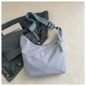 Detail of light blue nylon hobo bag with braided zipper pull and adjustable strap