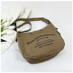 Gros plan d'un sac cabas en toile marron avec lettrage imprimé et boucle de sangle ajustable
