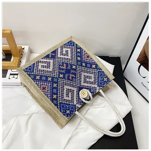 Detailed view of canvas tote bag with geometric patterns, wooden button, and rope handle