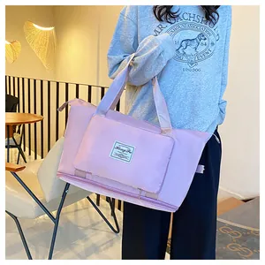 Pink waterproof travel duffel bag detail showing the zippered expandable bottom layer