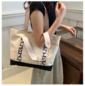 Sac fourre-tout en toile avec anses roses et détails de logo porté par un modèle