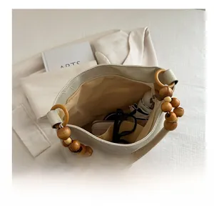 Top view of spacious cream tote bag showing interior storage with unique wooden bead handle
