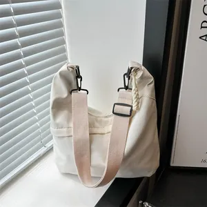 Minimalist cream white crescent tote bag with adjustable wide strap and black hardware