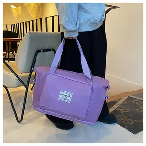 Detail of light purple travel bag with durable straps held by a model in casual setting