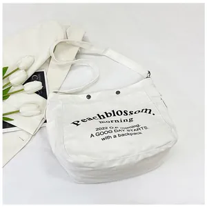Détail d'un sac cabas en toile blanche avec lettrage Peachblossom et sangle