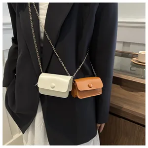 Detail of minimalist mini crossbody chain bags in cream white and vintage brown colors