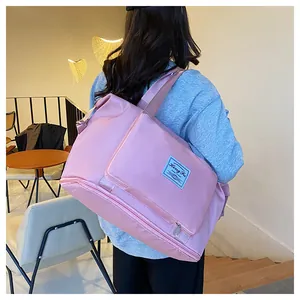 Pink waterproof nylon travel bag with bottom expansion layer and woven shoulder strap