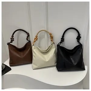 Detailed view of large tote bags with unique beaded ring handles in three classic colors