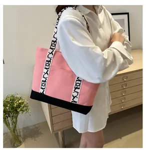 Sac fourre-tout en toile rose avec bandoulière à lettres et poche porté par un mannequin
