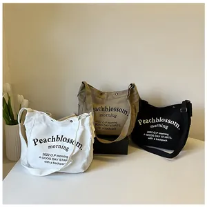 Trois sacs cabas en toile blanc, kaki et noir avec imprimé artistique de lettres élégant