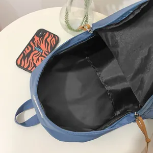 Μινιμαλιστικό μπλε σακίδιο πλάτης με ευρύχωρη κύρια θήκη και καφέ λαβές φερμουάρ