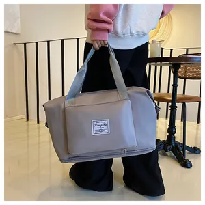 Detail showing high-density water-resistant nylon fabric and brand logo on grey travel bag