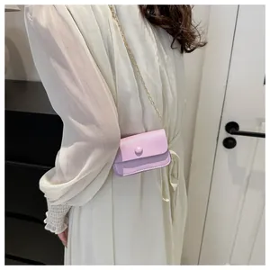 Detail view of mini lavender leather crossbody bag with elegant gold chain and round buckle