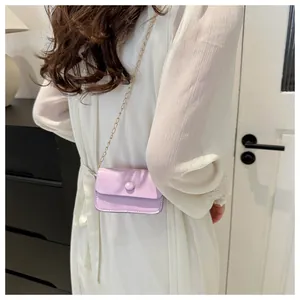 Close-up of lavender purple mini square crossbody bag with delicate gold chain strap