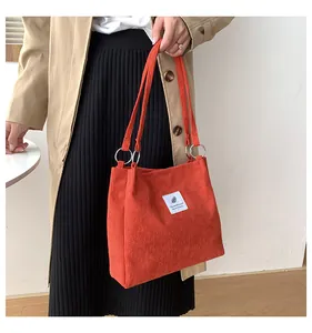Detail of caramel corduroy tote bag showing vertical ribbed texture and fabric patch